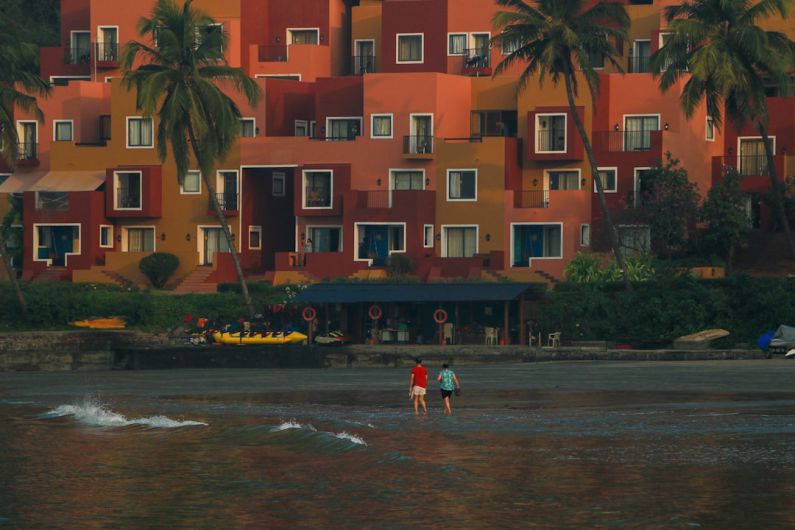 Beach Resorts - a couple of people standing on top of a body of water