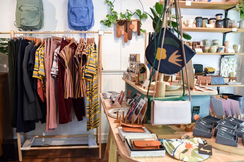 Boutiques - assorted-colored clothes on rack near brown wooden table