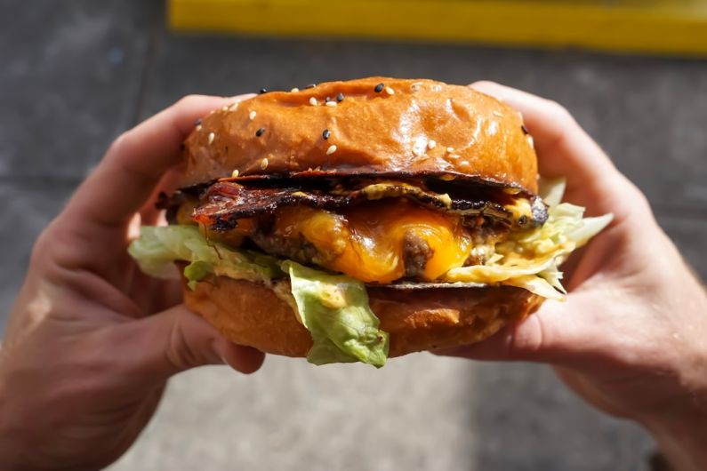 Foodie Tour - person holding cheese burger