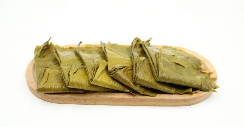 Tamales - Stuffed Wine Leaves on a Wooden Plate